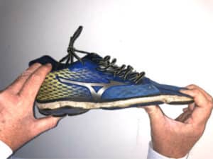 A dead shoe test - hands are trying to bend the front of a running shoe backwards.